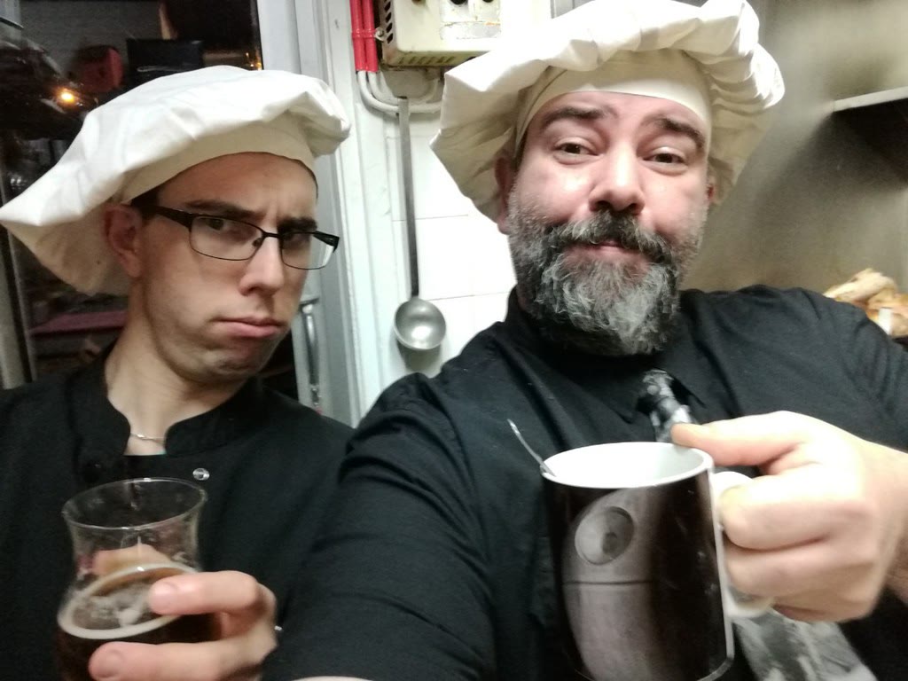 Deux membres de l'équipe en toque qui trinquent