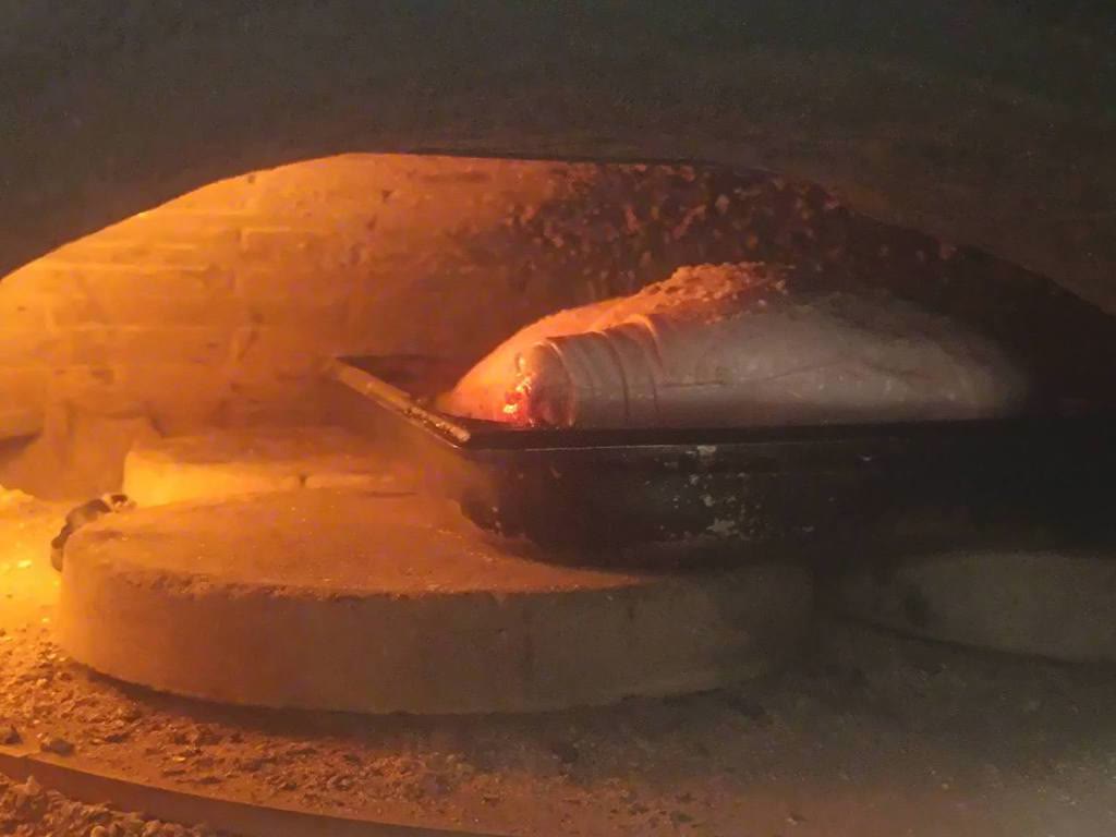 La bouche du four à bois, une plaque en train de cuire sur la sole