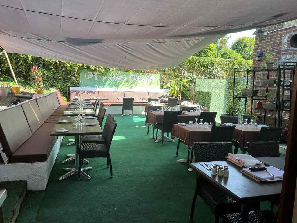 La terrasse abritée sous sa toile, tables dressées côté jardin