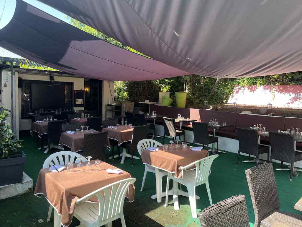 Tables de la terrasse, nappes et verdure
