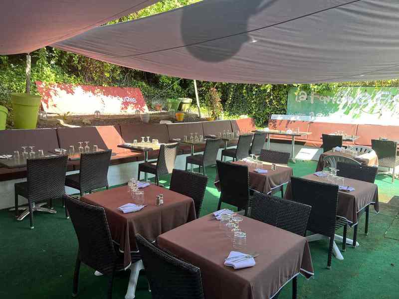 Tables de la terrasse avec nappes et verdure